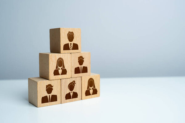 Pyramid of blocks with workers. Putting people in their places. Assemble a team of employees. How many workers can you effectively manage. Hiring and recruiting new members.