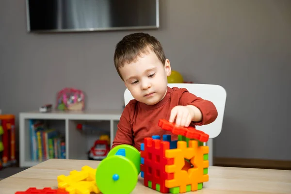 Egy Aranyos Figyelmes Kétéves Kisfiú Egy Gyerekasztalnál Sokszínű Válogatóval Játszik — Stock Fotó