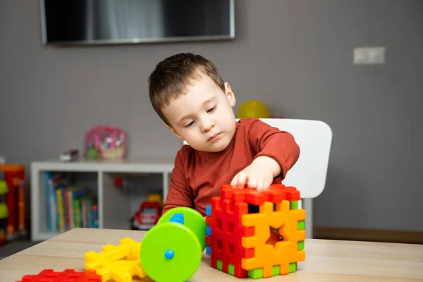Egy Aranyos Figyelmes Kétéves Kisfiú Egy Gyerekasztalnál Sokszínű Válogatóval Játszik — Stock Fotó