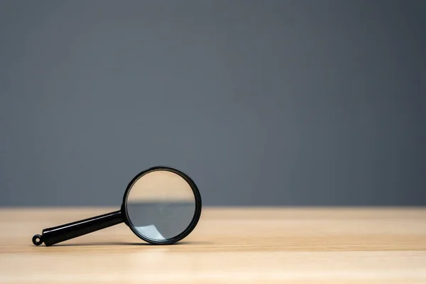 Magnifying glass on a grey background. Search and analysis, analytics and study. Pay attention to details and problems. Find something. Journalistic investigations and research. Search tool