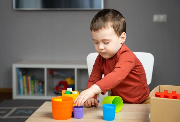 Egy Két Három Éves Gyönyörű Kisfiú Egy Asztalnál Gyerekszobában Játékokkal — Stock Fotó