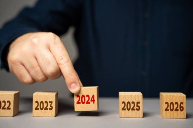 The coming of 2024. The man determines the next year. Reflecting on past achievements and experiences, looking forward. Embracing new trends, making forecasts, setting plans for coming future. clipart
