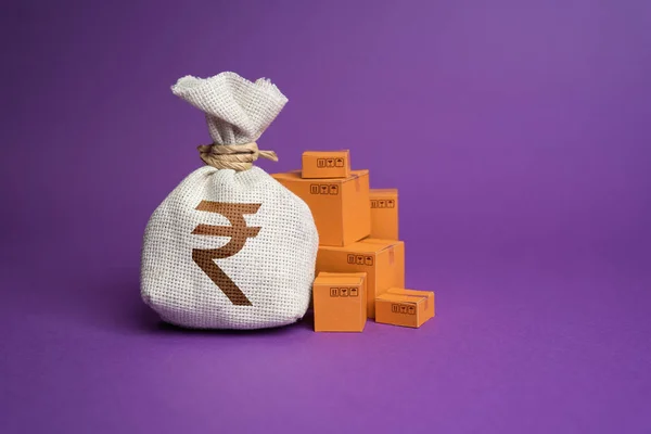 Goods boxes and indian rupee money bag. Budget purchases, large purchase orders. Global currency. Import and export. Profit from sales and production of goods, economic growth. Trade deal.