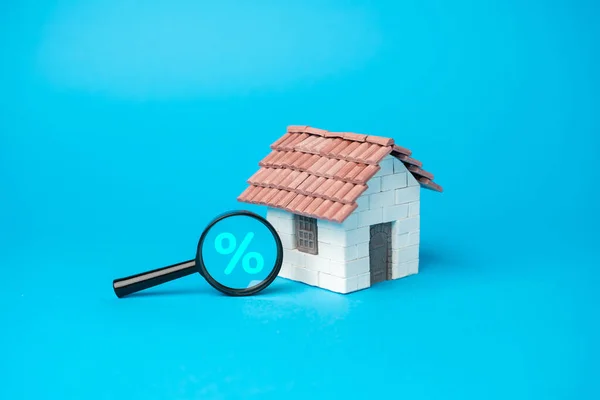 House and money bag with magnifying glass and percent symbol. Remortgage concept. Process of paying off your mortgage with the proceeds from a new mortgage using the same property as security.