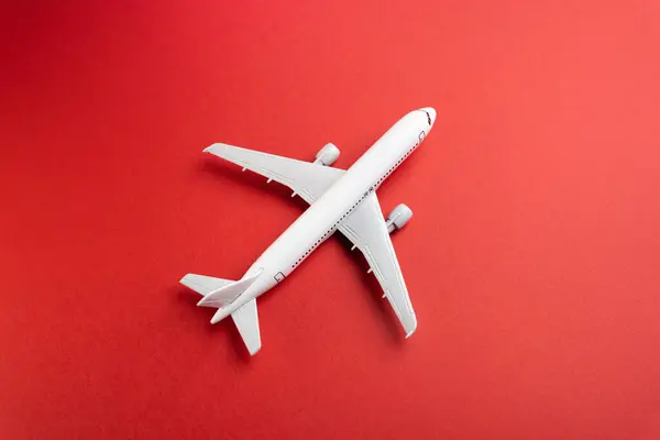 White plane on a red background. Airline operators, air carriers. Business and tourism. Travel. Logistics and transport infrastructure. World communication and commercial flights.