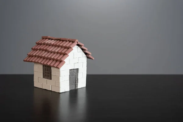 Toy house made of bricks on a gray background. Choosing a home to buy. Highlighted house. Choose the best housing to by or rent. Get a mortgage loan. Suitable. Real estate market offers overview.