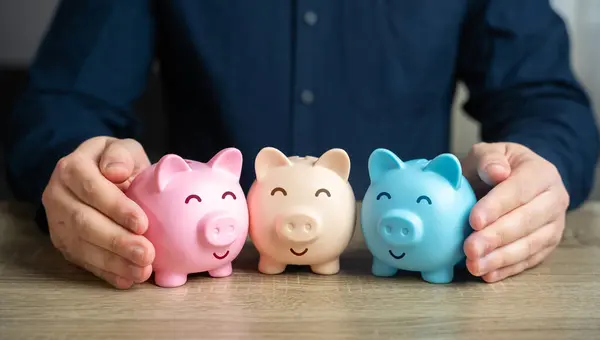 A man puts together piggy banks. Create your investment portfolio. Manage assets. Bank deposits and savings. Diversification of investments. Store and accumulate funds.