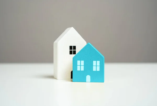 Wooden figures of houses, minimalism. Realtor services. Buying and selling. Housing options. Affordable housing. Mortgage.