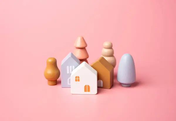 Houses and tree figures on a pink background. Affordable housing. Buying a nice house. Garden , landscape design. Figurine. Mortgage and loan.