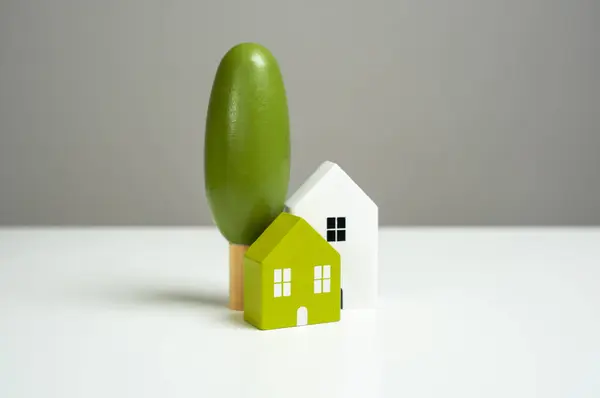 Homes and real estate. House and decorative trees, figurines. Buying and selling real estate. Housing prices.