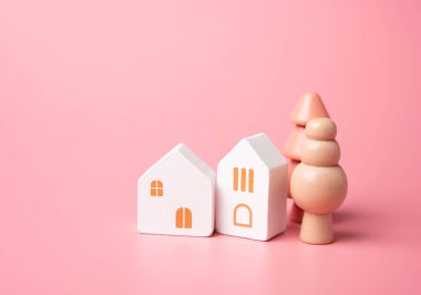 Pastel pembe renkli ev ve ağaçlar. Bir ev al. Uygun fiyatlı konutlar. İpotek. Samimi ve nazik tonlarda.