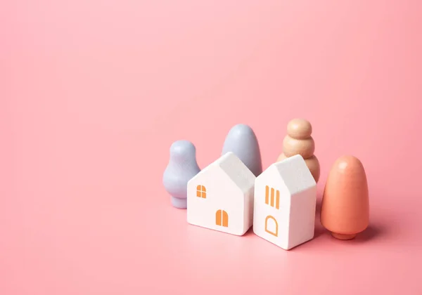 Figures of houses and trees on a pink background. Buy or rent a home. A pink dream in your own home. Mortgage and loan. Affordable housing. Buying a nice house.