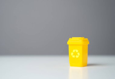 Sarı geri dönüşüm kutusu ve kopyalama alanı. Yuvarlak ekonomi. Doğal kaynakları korumak, atıkları azaltmak, geri dönüşüm endüstrisinde iş yaratmak. Geri dönüşümlü malzeme satmak veya yeşil projeler için ödenek almak.