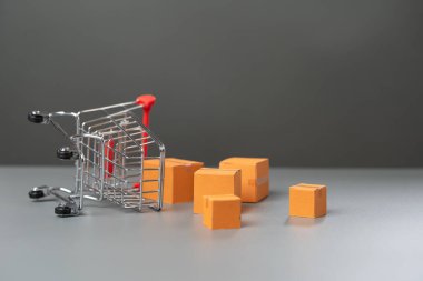 Kutular dolusu malın döküldüğü ters dönmüş bir alışveriş arabası. Mal talebinde bulunun. Alıcıların satın alma gücünde azalma. Pazar araştırması, pazarlama.