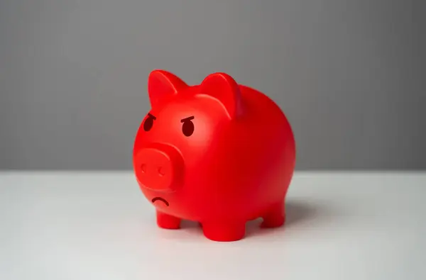 Angry red inflated piggy bank. Inflation is burning savings. Overheated financial market. Difficult economic conditions. Heavy burden on the budget, high expenses and the likelihood of bankruptcy.