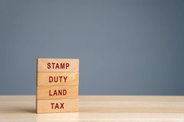 Stamp duty land tax SDLT concept. Taxes assessed during the transfer of real estate between two parties. Buying housing and land. Property. Wooden blocks clipart