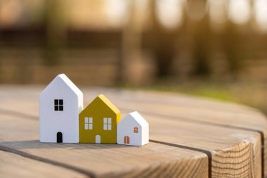 Tahta evler güneşli bir günde açık havada sıralanır. Gayrimenkul ve uygun fiyatlı konut kavramı. İpotek, borç. Çevre dostu ev