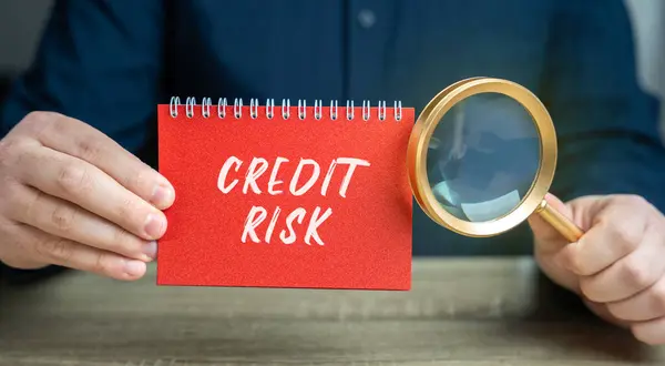 Credit risk concept. Financial loss resulting from a borrower\'s failure to repay a loan. Business and finance. Notepad and magnifying glass in the hands of a businessman