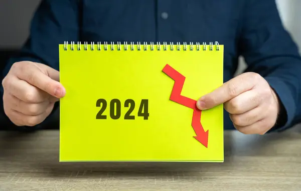 stock image 2024 and down arrow. Economic crisis and recession. Bankruptcy, finance crisis and forecasting. Analysis and analytics. Notepad in the hands of a businessman