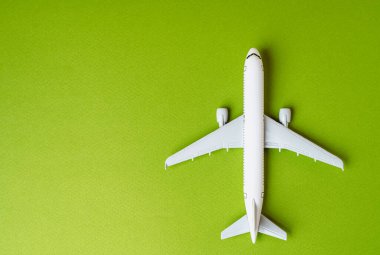 Yeşil arka planda yolcu uçağı ve mesaj için yer. Çevre dostu yakıt. Havacılık endüstrisinde teknolojik yenilikler. Yeşil hava ulaşımı