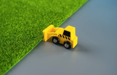 İnşaat alanını genişleten bir buldozer gri beton lehine yeşilliği ortadan kaldırıyor. Teknolojik gelişim için doğanın yok edilmesi. Kentleşme, çevre üzerindeki artan etki.