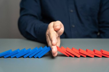 A man stops two domino chains from colliding. The concept of stopping a conflict and preventing further escalation. Elections and confrontation of the parties. Mentoring. Find points of compromise. clipart