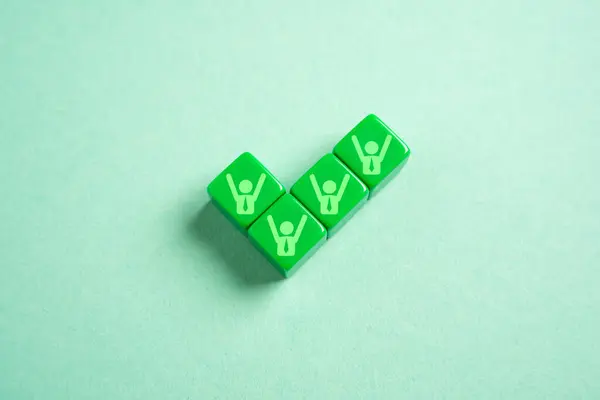 stock image A green tick with symbols of jubilant team members. Achieve success. Get permission. Sign a profitable contract. Will complete the project, approve the work. Successful adoption. Team success