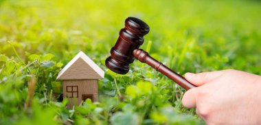 Judge's gavel near miniature wooden house outdoors. Real estate court decisions. Property inheritance litigation. Establishment of ownership. clipart