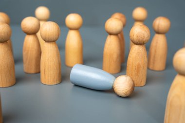 Yerde yatan gri bir insan figürü diğer insan figürleriyle çevrilidir. Depresyon ve tükenme kavramı. Zihinsel sağlık farkındalığına ve desteğe ihtiyaç var