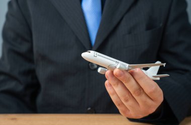 Bir işadamının ya da memurun elinde havalanan bir uçak. Yeni uçuş rotaları ve uçuşlar başlatılıyor. Yeni uçak alıyorum. Giderek artan yolcu trafiğinde havaalanları ve altyapı genişliyor