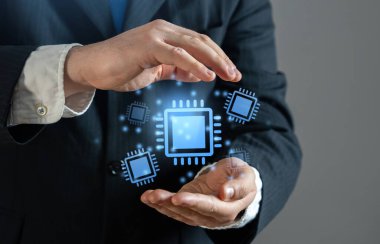 Mikroçiplerin ve yarı iletken bileşenlerin hologramlarını elinde tutan bir iş adamı. İşlemciler ve mikroçipler. Yapay zeka ve bilgisayar gücü talebi.