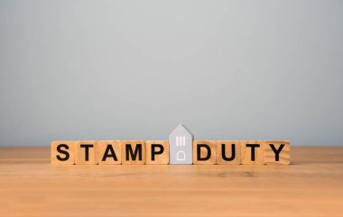 Pul görevi konsepti. İki taraf arasında gayrimenkul transferi sırasında alınan vergiler. Konut ve arazi satın almak. Mülk. Damga Vergisi SDLT. Tahta bloklar