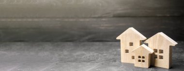 Siyah arka planda minyatür ahşap evler. Uygun fiyatlı konutlar. Arama en iyi seçenek daire ve emlak, kira. Uzayı kopyala, afiş