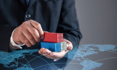 Dünya ticaret haritasına karşı nakliye konteynerleri taşıyan bir işadamı. Küresel ticaret, lojistik ve ticaret. Uluslararası tedarik zincirlerinin, ihracatın, ithalatın ve küresel pazarların genişlemesinin sembolü.