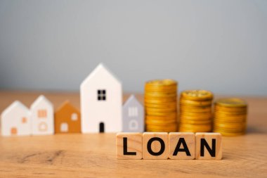 Tahta bloklar, krediler ve evler. Borç veren kişinin zaman içinde faiziyle birlikte geri ödeme beklentisi ile borç sahibine para veya mal varlığı sağladığı mali anlaşma. Emlak kavramı