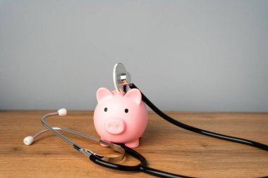 Kırmızı domuz ve steteskop. Sağlık kontrolü ve sağlık sigortası için tasarruf parası. Tıp ve finans kavramı