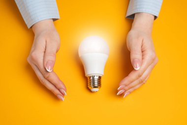 Eller ampul fikrini korur. Fikri mülkiyet koruması kavramı. Yenilik güvenliği. Yaratıcı savunma, yasal koruma ve orijinal kavramların mülkiyeti.