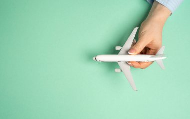 Yolcu uçağı kızın elinde ve mesaj için arka planı boş. Uçuş ve seyahat kavramı. Turizm ve iş.