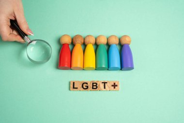 Büyüteçle el, LGBT temsilcileri arasından insan figürleri seçiyor. Kendinizi cinsel yönelimler listesinde bulun. Kendini tanıtma, cinsel yönelimleri keşfetme. Tahta bloklar