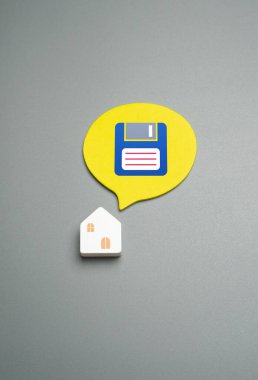 Kaydetme sembolü olarak ev ve disket. Yaşamak için konut. Bir ev barınağı, yaşam alanını korumayı ya da konutu temel, korunan bir varlık olarak temsil eder. Güvenli bir yer.