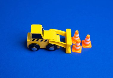 Sarı bir buldozer trafik konilerini hareket ettiriyor. Kısıtlamaları kurma ya da kaldırma kavramı. Yeni kurallar uygulanıyor. İnşaat bölgeleri. Politika düzenlemeleri ve kamu güvenliği tedbirleri.