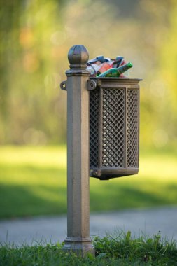 Parktaki eski metal çöp kutusu.