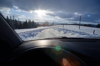 winter landscape with snow-covered road. View from car