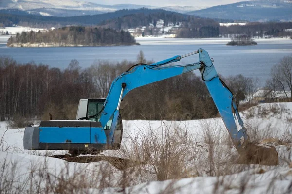 a large excavator working on the snow