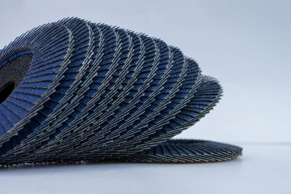 Ламелларный шлифовальный диск для ручной шлифовки, деталь синего цвета на белом фоне.