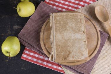 An old shabby light brown book on a bamboo stand, close-up top view