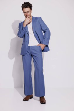 Gözlüklü, kendine güvenen, şık esmer adam ve gri üzerinde poz veren klasik takım elbiseli adam. 