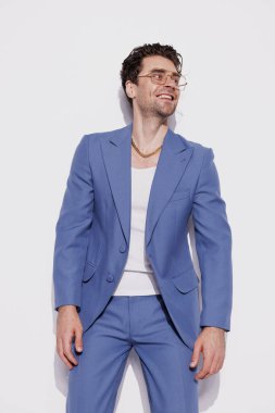 Eski takım elbiseli neşeli ve şık bir adam, altın zincir ve gri gözlüklü. 