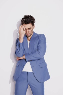 Mavi takım elbiseli şık esmer model ve gri aksesuarlı altın aksesuarlar. 