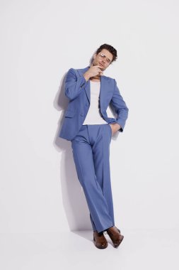 İyi giyimli gözlüklü adam ve gri arka planda mavi takım elbiseli adam.